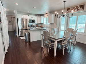 Dining space with sink, a chandelier, a textured ceiling, and dark hardwood / wood-style flooring