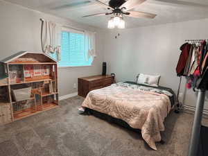 Carpeted bedroom with a textured ceiling and ceiling fan