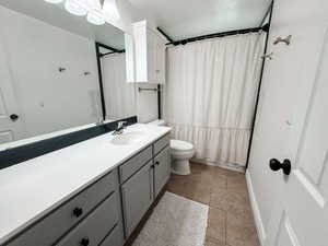 Bathroom with vanity, tile patterned floors, and toilet