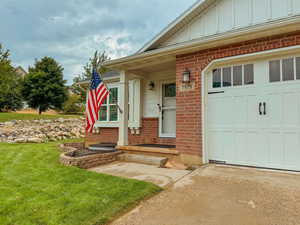 Entrance to property with a garage and a yard