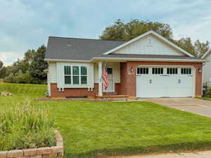 View of front of property featuring a garage and a front lawn