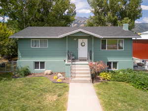 View of front facade featuring a front lawn and a mountain view