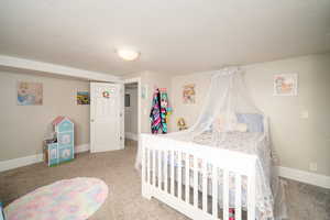 Bedroom with light carpet and a textured ceiling