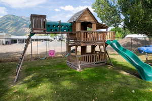 View of jungle gym with a lawn and a mountain view