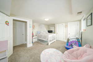 Bedroom with light carpet and a textured ceiling