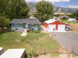 Exterior space with a yard, a garage, a mountain view, and an outbuilding