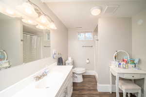 Bathroom featuring vanity, laminate flooring, and toilet