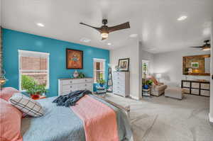 Carpeted bedroom featuring ceiling fan