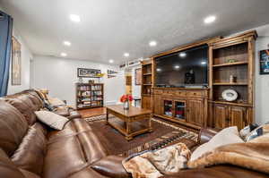 Living room with a textured ceiling and hardwood / wood-style flooring