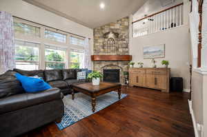 Living room with high vaulted ceiling, a fireplace, and dark hardwood / wood-style flooring