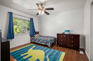 Bedroom with dark wood-type flooring and ceiling fan