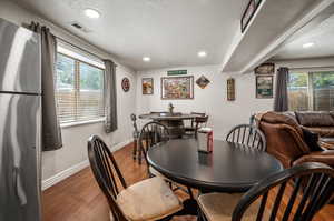 Dining area featuring hardwood / wood-style flooring, a wealth of natural light, and a textured ceiling