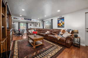 Living room featuring a textured ceiling and dark wood-type flooring