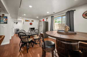 Dining room featuring a textured ceiling and hardwood / wood-style floors