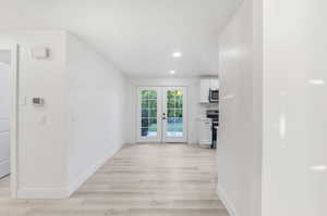 Hallway featuring light hardwood / wood-style floors and french doors