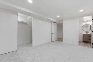 Basement with light carpet and sink