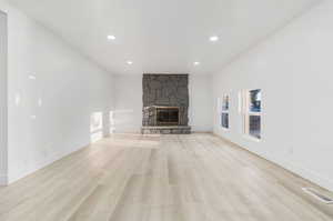 Unfurnished living room with a fireplace and light wood-type flooring