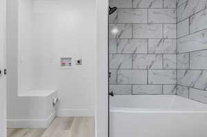 Bathroom featuring wood-type flooring and tiled shower / bath