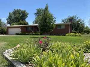 View of front of property with a garage and a front yard