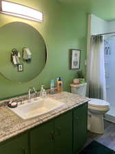 Bathroom featuring hardwood / wood-style floors, toilet, and vanity