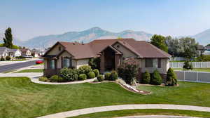 View of front of property with a mountain view and a front yard