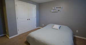 Carpeted bedroom featuring a closet