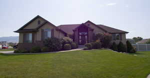 View of front of home with a mountain view and a front lawn