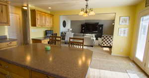 Kitchen with pendant lighting, an inviting chandelier, and light colored carpet