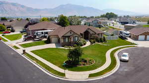 View of front facade featuring a garage, a mountain view, and a front lawn