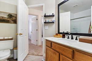 Bathroom featuring hardwood / wood-style flooring, toilet, and vanity