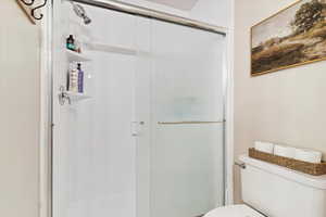 Bathroom with a shower with door and toilet