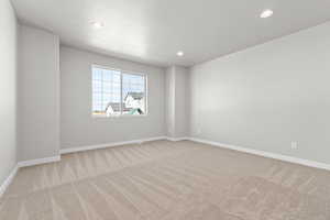 Empty room featuring a textured ceiling and light colored carpet