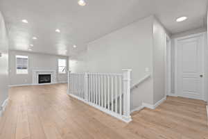 Corridor featuring light hardwood / wood-style floors and a textured ceiling