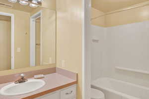 Full bathroom featuring bathing tub / shower combination, toilet, and vanity