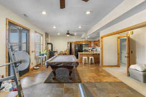 Recreation room with ceiling fan, light tile patterned floors