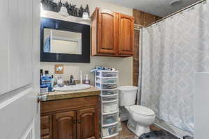 Bathroom with vanity, toilet, a textured ceiling, and tile patterned flooring