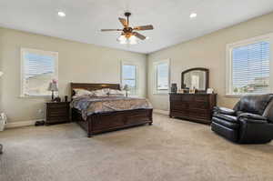 Bedroom with ceiling fan and light colored carpet