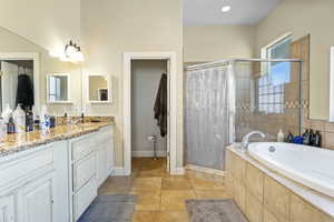 Bathroom with shower with separate bathtub, vanity, and tile patterned flooring