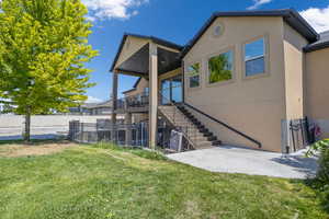 Rear view of property with a patio area and a lawn