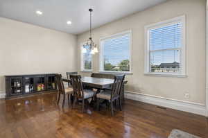 Dining area with an inviting chandelier and dark hardwood / wood-style floors