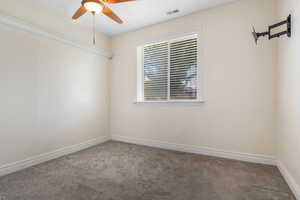 Unfurnished room with carpet floors, ceiling fan, and a wealth of natural light