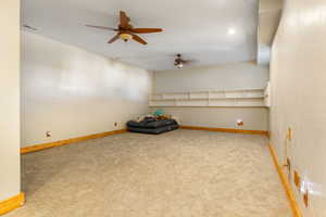 Carpeted spare room featuring ceiling fan