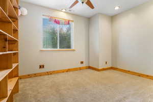 Carpeted spare room with ceiling fan