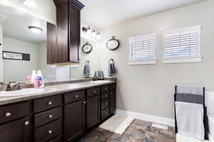 Bathroom featuring tile patterned flooring and dual bowl vanity