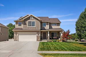 Craftsman inspired home with a garage and a front yard