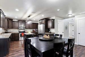 Dining area with dark hardwood / wood-style flooring, sink, and a textured ceiling