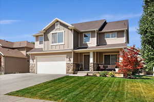 Craftsman inspired home featuring a garage and a front yard