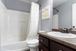 Full bathroom featuring vanity, toilet, and shower / tub combo