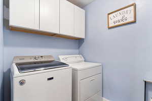 Clothes washing area with cabinets and washer and dryer