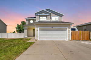 View of front property with a garage and a yard